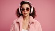 © prasanth - Woman in color pink jacket and sunglasses with headphones on pink background