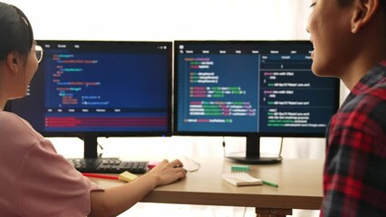 Slow motion back end software developer engineer for computer programming working together on debugging writing computing code, solving complex algorithms display on monitor in office. Burgeoning