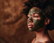 © Manu Prats - Woman with afro using a nourishing green facial mask, natural skincare and self-care routine