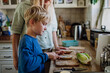 © Halfpoint - Boy helping mother to make school lunch in the kitchen. Preparing healthy snack for school.