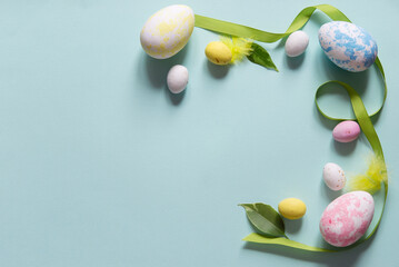 Canvas Print - Easter concept with easter colorful eggs and decorative ribbon! Delicate pastel blue empty background with copy space. Flat lay