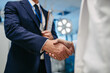© Halfpoint - Pharmaceutical sales representative presenting new medication to doctor in medical building, shaking hands.