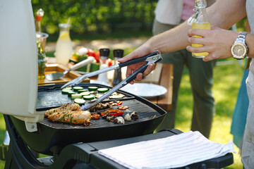 Meat and vegetables grilling on outdoor grill. Outdoor grill or BBQ party in the garden.