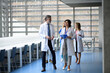 © Halfpoint - Team of doctors discussing test results, walking across corridor. Colleagues discussing patients diagnosis.