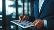 © Ilmi - Professional economist in suit analyzing business data on a tablet. Doing business.