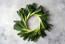 Fresh Green Leeks Arranged In A Circle On A Textured Gray Background, Ideal For Healthy Eating Concepts And Inclusion In Recipes