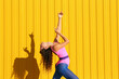© VISTA by Westend61 - Young woman wearing bodysuit dancing in front of yellow wall
