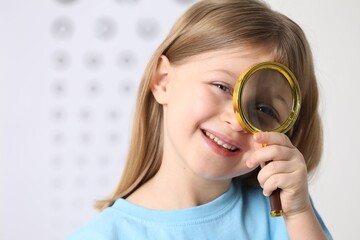 Sticker - Little girl with magnifying glass on blurred background