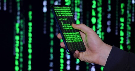 Wall Mural - close up of cell phone in the hand of a young hacker or programmer. on the background screen and pho