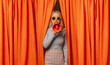 © VISTA by Westend61 - Woman talking through megaphone standing amidst orange curtains
