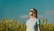 © VISTA by Westend61 - Blond woman wearing sunglasses in rapeseed field