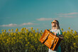 © VISTA by Westend61 - Woman carrying brown suitcase standing in rapeseed field