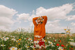 © VISTA by Westend61 - Woman with head in hands standing amidts flowers in chamomile field