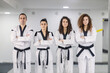 © Dusan Petkovic - Portrait of taekwondo girls wearing kimono and black belts with their coach and looking at the camera.