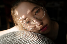 Young Woman Resting On Disco Ball