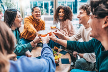 Group Of Young People Enjoying Happy Hour Sitting At Bar Table - Happy Multiracial Friends Cheering Beer Glasses At Brewery Pub - Life Style Concept With Guys And Girls Having Dinner Party Together