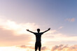 © Marcio - Silhouette of a man with arms open against a beautiful sky, expressing gratitude for success and happiness