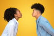 Playful young African American couple giving each other a kissy face, with eyes closed