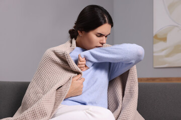 Sticker - Woman coughing on sofa at home. Cold symptoms