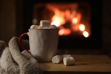 Wall Mural - Tasty drink with marshmallows in cup on wooden table, closeup. Space for text