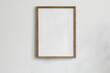 © tabitazn - Single picture mockup poster hanging in the middle of white wall. Portrait large 50x70, 20x28, a3,a4. Empty wooden frame mockup. Clean, modern, minimal design. Indoor interior decor, show text, or