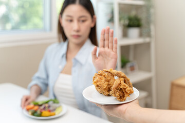 Poster - Diet food loss weight concept, Hand of woman pushing fast food away and avoid to eat fried chicken to control cholesterol and sugar.