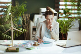 Fototapeta Paryż - pensive business woman in light business suit in green office