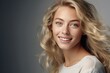 © Fotograf - A woman with long blonde hair smiling directly at the camera. Suitable for various uses