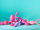 Fototapeta  - Heap of silicone sex toys over turquoise background