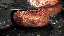 A Beef Burger Falls Into A Hot Pan With A Splash Of Oil. Filmed On A High-speed Camera At 1000 Fps. High Quality FullHD Footage