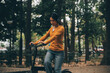 © ARMMY PICCA - Happy young Asian woman while riding a bicycle in a city park. She smiled using the bicycle of transportation. Environmentally friendly concept.