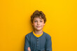 © Anastasiia - Confident Young Boy Striking Pose Against Vibrant Yellow Backdrop
