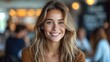 © Jevjenijs - a close up of a woman with blonde hair and blue eyes smiling at the camera with people in the background.
