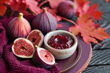 Fall Themed Background With Sliced Figs On A Ceramic Plate Accompanied By A Magenta Towel And Red Maple Leaves On A Dark Purple Board Fig Jam In A Ceramic Bowl
