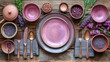  a table topped with plates and bowls filled with different types of purple foodstuffs and spoons next to purple flowers and a wooden table with purple plates and silverware.