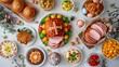Traditional Easter dinner or brunch with ham, colored eggs, hot cross buns, cake and vegetables. Easter meal dishes with holday decorations. Top view, flat lay