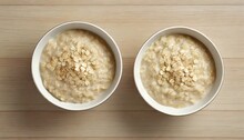 Top View Of Two Bowls Of Oatmeal On Table