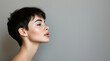 © Nataliia_Trushchenko - Young female model showing stylish short hairdo side view. Portrait of a beautiful girl with a short haircut. Grey background. Profile side view portrait of attractive dreamy girl.
