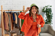 © LIGHTFIELD STUDIOS - creative asian designer in orange clothes and panama hat in modern fashion atelier, small business
