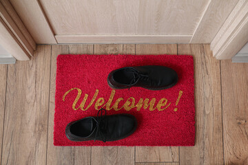 Wall Mural - Welcome doormat with shoes in hall, top view