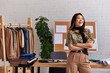 © LIGHTFIELD STUDIOS - excited stylish asian designer with folded arms laughing near work desk in private fashion atelier