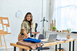 © LIGHTFIELD STUDIOS - joyful asian woman with sewing pattern looking at camera near laptop and fabrics, personal stylist