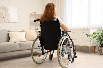 Poster - Young redhead woman in wheelchair at home, back view