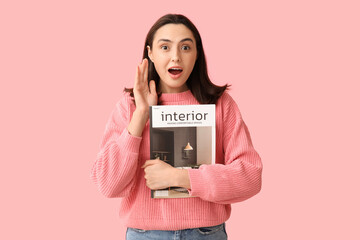 Wall Mural - Surprised young woman with interior magazine on pink background