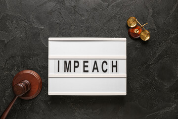 Board with word IMPEACH, judge gavel and scales of justice on black grunge background