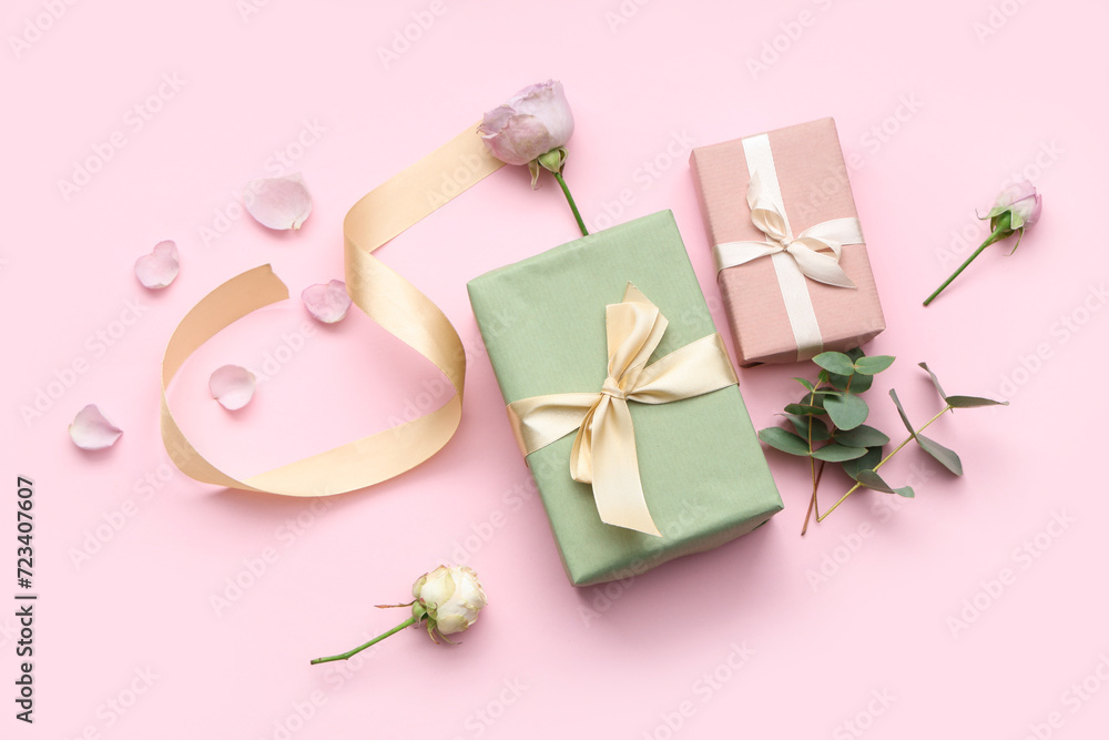 Gift boxes with beautiful roses and petals on pink background. International Women's Day
