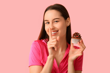 Wall Mural - Young woman with sweet cupcake on pink background. Valentine's Day celebration