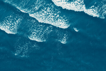 Wall Mural - Sea blue surface aerial view, abstract blue sea water with white wave for background