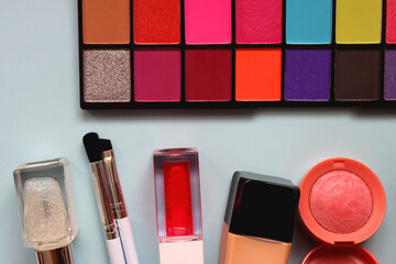 Wall Mural - Various colorful make up products on bright blue background. Flat lay.