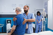 © DC Studio - Retired patient receives chiropractic care for back discomfort in order to heal physically. Nurse aids old man in recovering from spine injury and providing orthopedic massage for physical therapy.